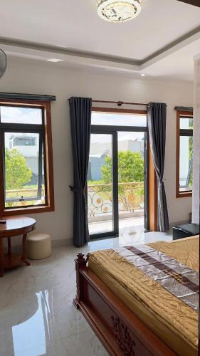 a bedroom with a large bed and large windows at Khách Sạn An Nhiên in Bến Cát