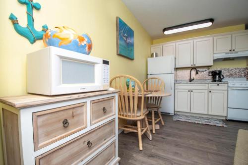 a kitchen with a microwave on top of a dresser at Driftwood Landing 16 in Naples