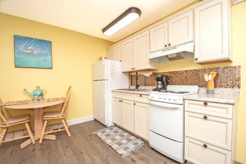 a kitchen with a table and a white refrigerator at Driftwood Landing 16 in Naples