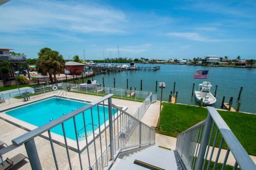 a balcony with a swimming pool and a marina at Driftwood Landing 16 in Naples