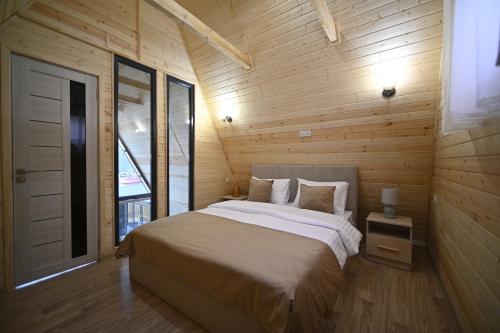 a bedroom with a bed and a wooden wall at Avra Resort Tsaghkadzor in Tsaghkadzor