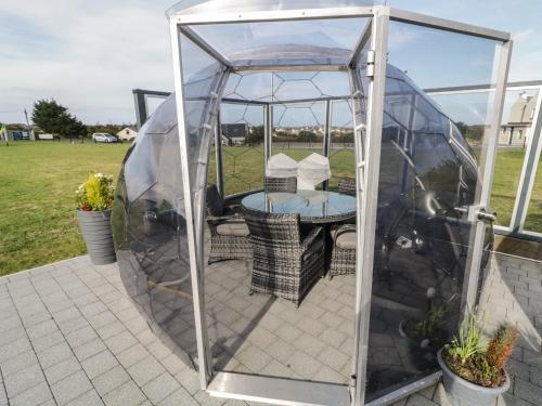 a gazebo with a table and chairs in it at Number 2 Dome in Doirí Beaga