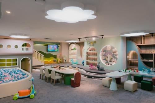 a room with a kindergarten with a playroom with tables and chairs at The Westin Surabaya in Surabaya