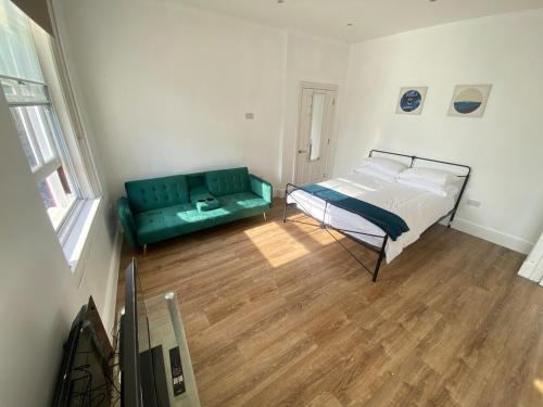 a bedroom with a bed and a couch at The Essex Atelier Studio Flat 2 in Chelmsford