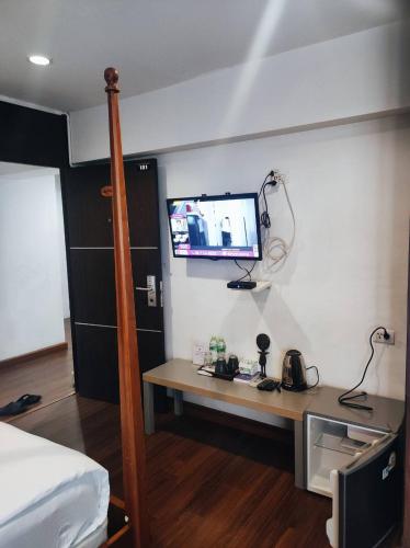 a room with a desk and a tv on the wall at mstay in Bangkok
