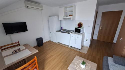 a small apartment with a kitchen and a living room at Apartments Mato with balconies, garden & the sea view in Seget Vranjica