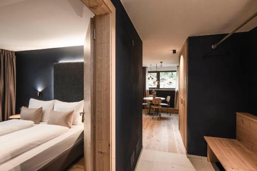 a bedroom with a white bed and a black wall at The Post Mountain Residence in Dobbiaco