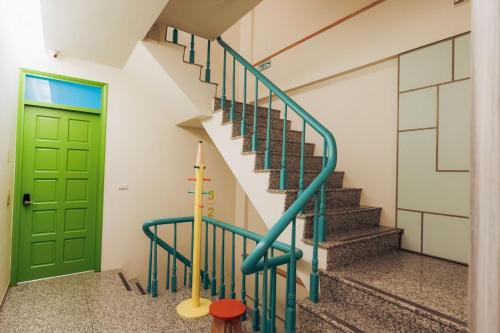 una porta e delle scale verdi in una casa di Elsa House a Tainan