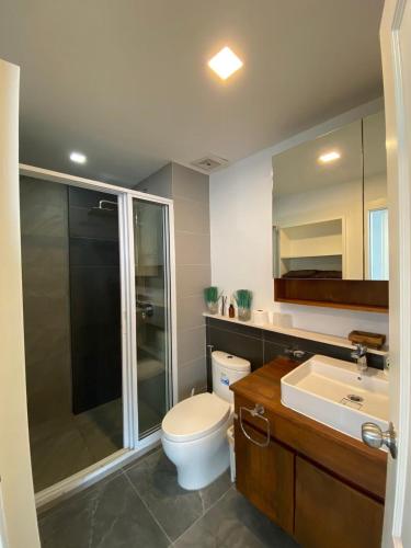 a bathroom with a toilet and a shower and a sink at The gallery condominium Ben in Jomtien Beach