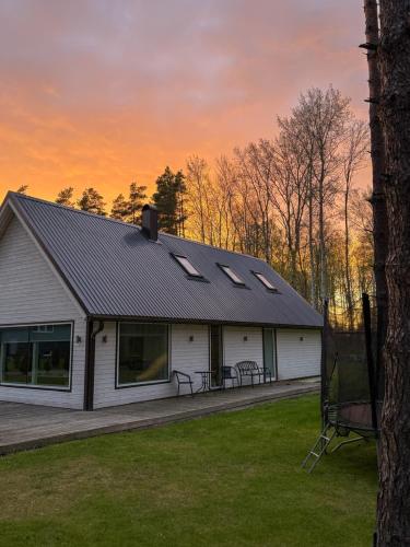 a white house with solar panels on the roof at Villa Männituka in Kirikuküla