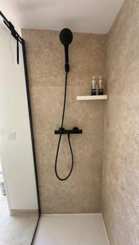 La salle de bains est pourvue d'une douche avec un pommeau de douche noir. dans l'établissement Véranda Pia, à Frontignan