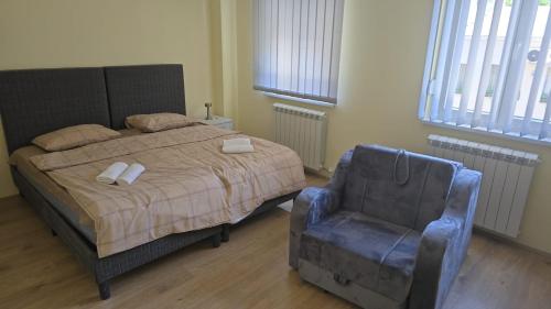 a bedroom with a bed and a blue chair at mir rooms and apartments in Belgrade