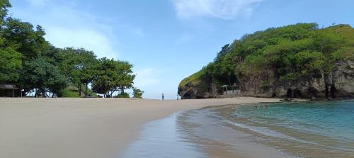 a beach with people swimming in the water at Moon view Bungalow's in Kelimutu
