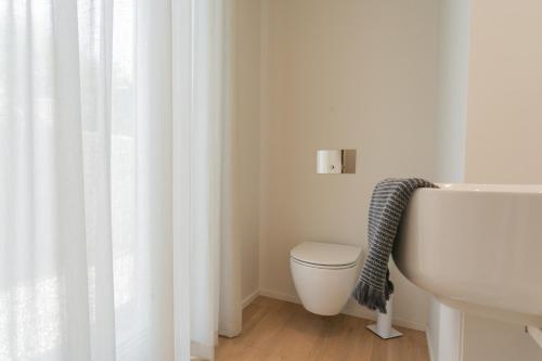 a bathroom with a white toilet and a sink at Valarin Luxury Apartments & Wellness, Vercana by Rent All Como in Vercana