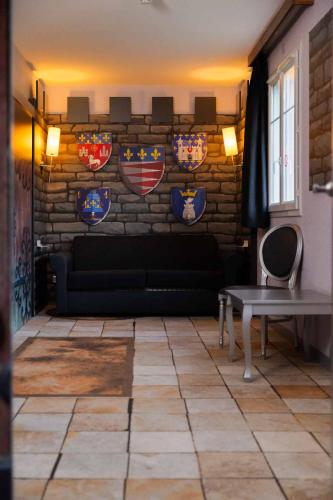 a living room with a couch and plates on a wall at Explorers Hotel Marne-la-Vallée in Magny-le-Hongre