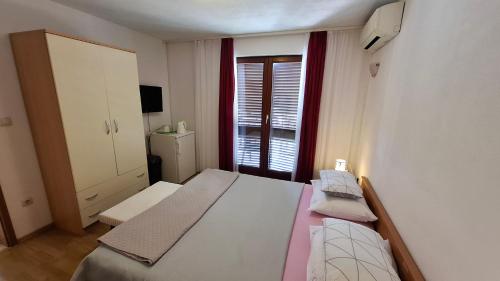 a bedroom with a large bed with a window at Apartments Mato with balconies, garden & the sea view in Seget Vranjica