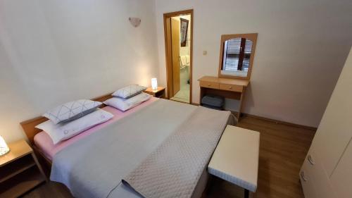a bedroom with a large white bed and a table at Apartments Mato with balconies, garden & the sea view in Seget Vranjica