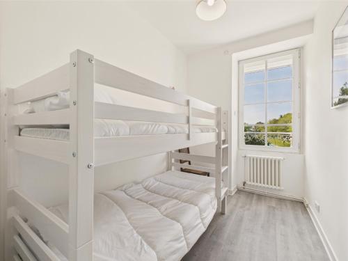 a white bedroom with two bunk beds and a window at Vue mer - 50 m du port - Maison pour 6 - Jardin in Le Croisic