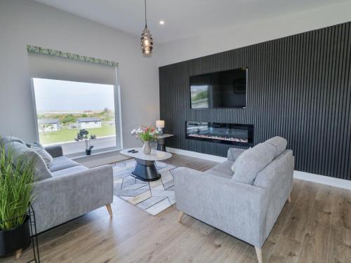 a living room with two couches and a fireplace at Number 6 Villa - The View in Doirí Beaga