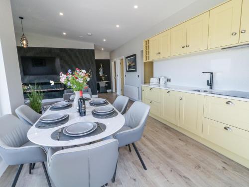 a kitchen and dining room with a table and chairs at Number 6 Villa - The View in Doirí Beaga