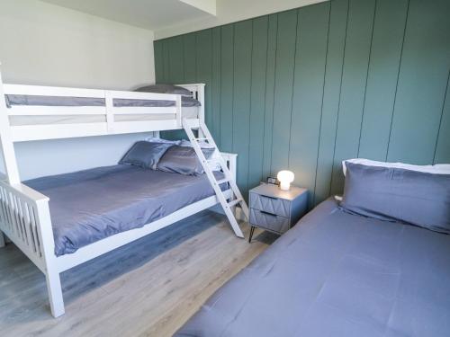 a bedroom with two bunk beds and a night stand at Number 3 Villa - The View in Doirí Beaga