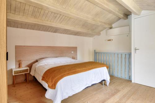 a bedroom with a large bed and a wooden ceiling at Piscine chauffée, jardin, magnifique villa pour 10 in La Guérinière