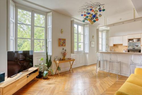 Il comprend un salon avec une télévision et une cuisine. dans l'établissement Appartement Lumiere - 10 min château, à Versailles