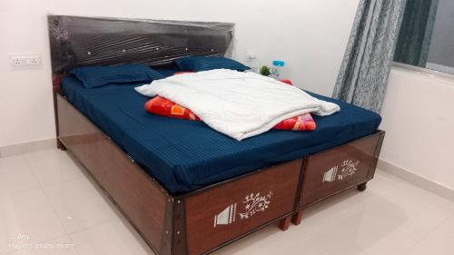 a bed in a room with blue sheets and pillows at Kedar view inn in Phata
