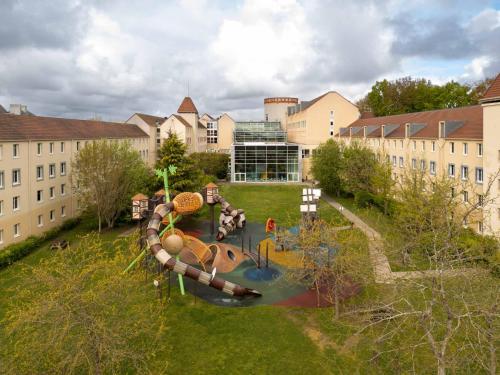 an aerial view of a playground in front of a building at Explorers Hotel Marne-la-Vallée in Magny-le-Hongre