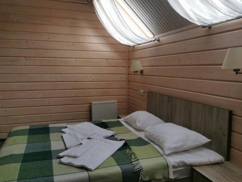 a bedroom with a bed with towels on it at Шале На бе́резі in Kvasy