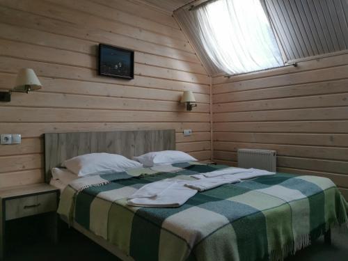 a bedroom with a bed in a wooden wall at Шале На бе́резі in Kvasy