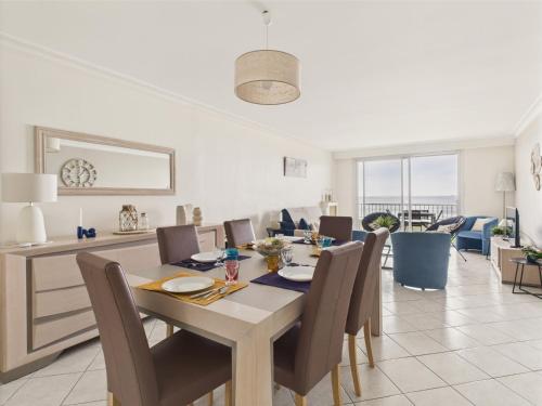une salle à manger avec une table et des chaises en bois dans l'établissement Vue mer - Appartement pour 6 - 5 m de la plage, à Pornichet
