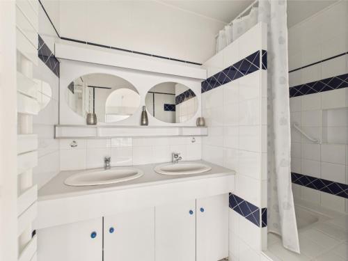 une salle de bain avec deux lavabos et deux miroirs dans l'établissement Vue mer - Appartement pour 6 - 5 m de la plage, à Pornichet