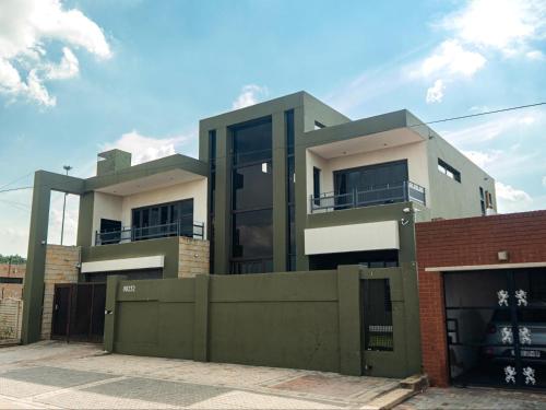 a building with a fence in front of it at Soweto Boutique Hotel in Soweto