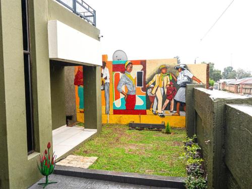 a building with a painting on the side of a wall at Soweto Boutique Hotel in Soweto