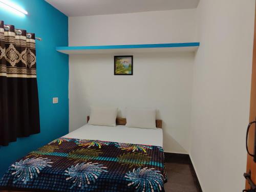 a bedroom with a bed with a blue wall at Valley View by Green Trails in Chikmagalūr
