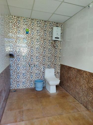 a bathroom with a toilet and a wall at Valley View by Green Trails in Chikmagalūr