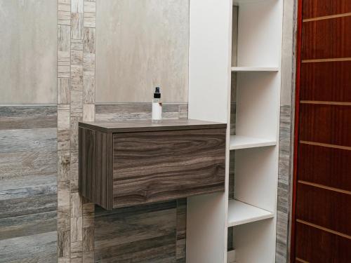 a bathroom with a wooden vanity in a book shelf at Soweto Boutique Hotel in Soweto