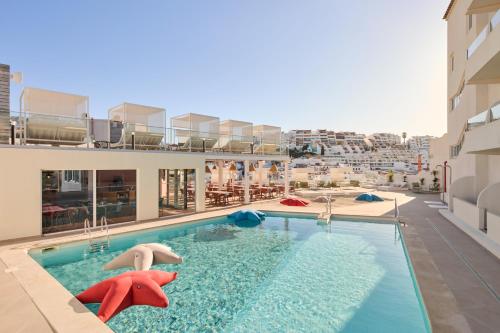 a swimming pool with two people in a building at Hotel Indigo Albufeira by IHG in Albufeira