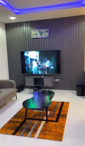 a living room with a tv and a coffee table at S A Luxury Apartments in Abuja