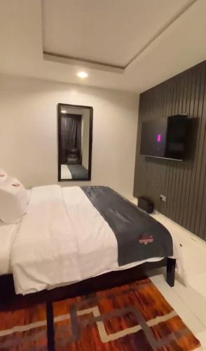 a bedroom with a bed with a mirror and a television at S A Luxury Apartments in Abuja