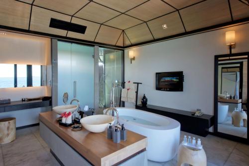 a bathroom with two sinks and a large tub at Lily Beach Resort and Spa - All Inclusive in Dhangethi