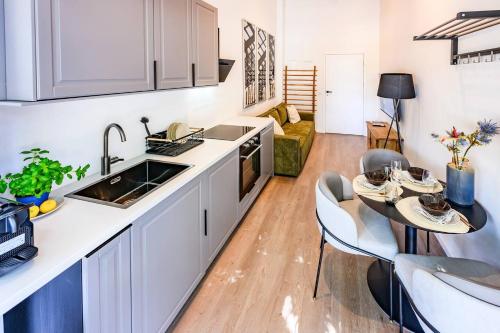a kitchen with a sink and a table with chairs at Cozy Lofts Next To Berliner Wall in Berlin