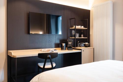 a hotel room with a desk and a bed at Schwarzer Adler - Concept Living in Vipiteno