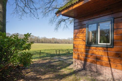 a building with a window on the side of a field at 't Eekhoornnest in Soest