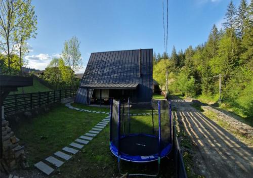 a house with a gambrel roof and a playground at Gloriosa Chalet in Voronet