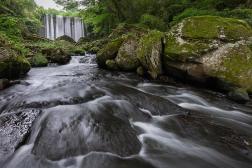 a river with a waterfall in the background at Sanso Tensui in Hita