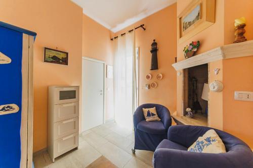 a living room with a blue chair and a fireplace at Casa a *POLIGNANO* con [Affaccio sul Mare] in Polignano a Mare
