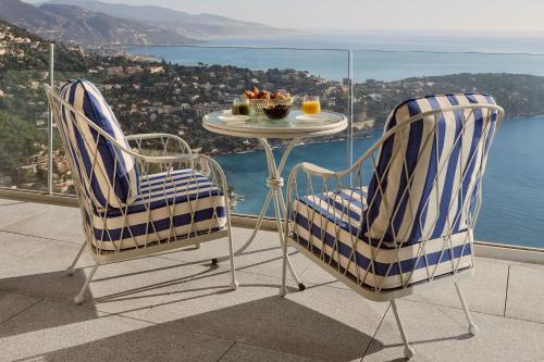 two chairs and a table on a balcony with a view at The Maybourne Riviera, Maybourne in Roquebrune-Cap-Martin