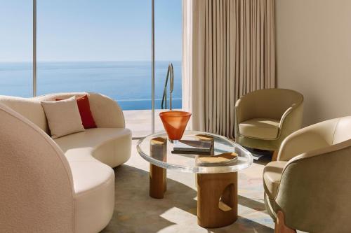 a living room with chairs and a glass table at The Maybourne Riviera, Maybourne in Roquebrune-Cap-Martin